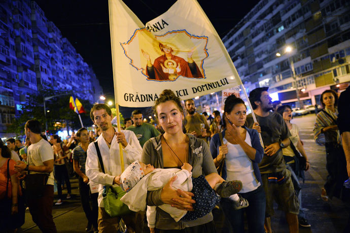 Protesters march and hold banners during the eighth day of demonstrations in Bucharest against the Rosia Montana Gold Corporation (RMGC), a Canadian gold mine project using cyanide, on September 8, 2013.(AFP Photo / Daniel Mihascu)