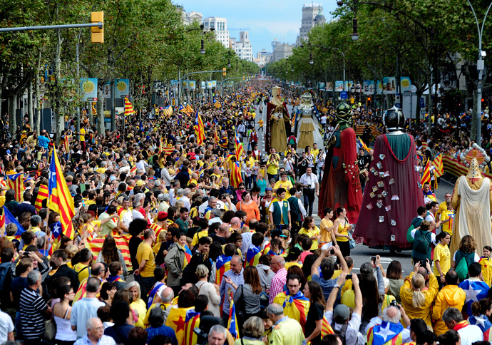 Giants walk past Catalans gathering in a bid to create a 400-kilometre (250-mile) human chain, part of a campaign for independence from Spain during Catalonia National Day, or Diada, on Passeig de Gracia in Barcelona, on September 11, 2013 (AFP Photo / Josep Lago) 