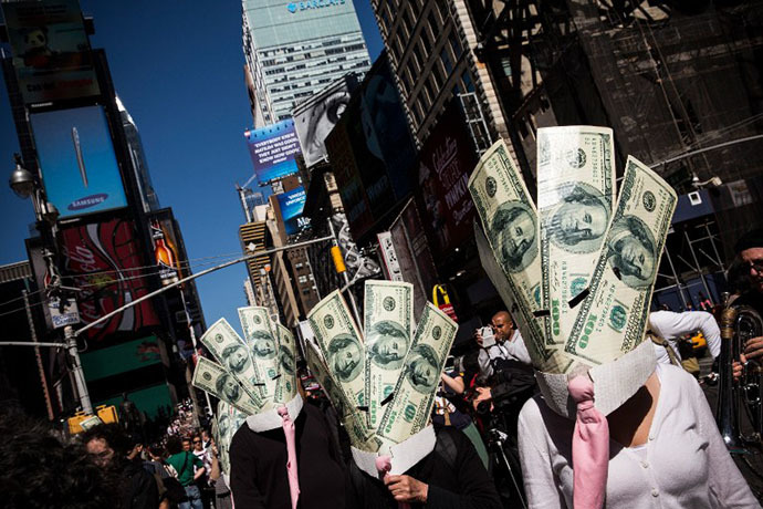 Occupy Wall Street protesters wearing masks made out of enlarged dollar bills act in a short skit in Times Square on September 17, 2013 in New York City. (AFP Photo / Andrew Burton)