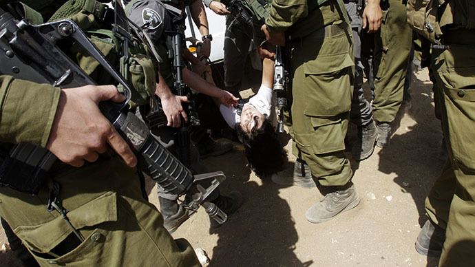 Israeli soldiers carry French diplomat Marion Castaing after removing her from her truck containing emergency aid, in the West Bank herding community of Khirbet al-Makhul, in the Jordan Valley September 20, 2013. (Reuters / Abed Omar Qusini)