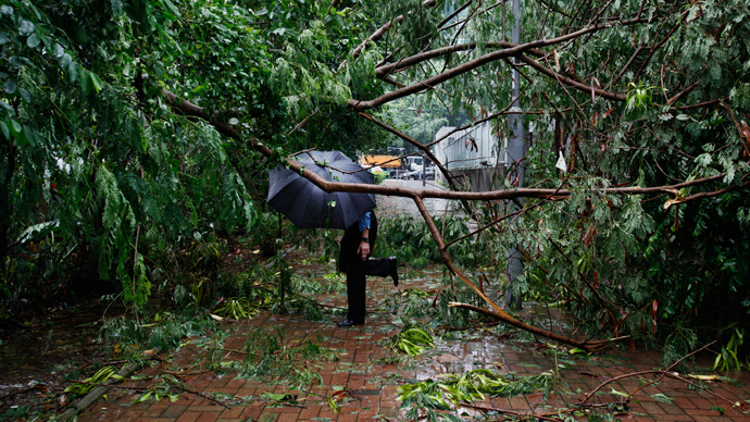 A man walks under fallen branches on a pavement at a residential district after Typhoon Usagi hit Hong Kong September 23, 2013 (Reuters / Bobby Yip)