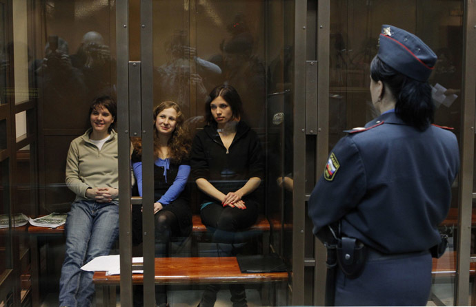 Members of the female punk band "Pussy Riot" (L-R) Yekaterina Samutsevich, Maria Alyokhina and Nadezhda Tolokonnikova sit in a glass-walled cage before a court hearing in Moscow October 10, 2012. (Reuters/Maxim Shemetov)
