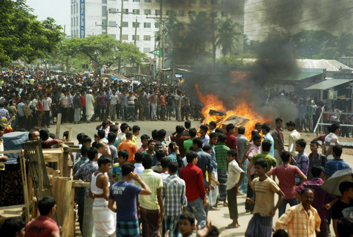Garment workers set fire in a bench as they block a street during a protest in Gazipur September 23, 2013. (Reuters)