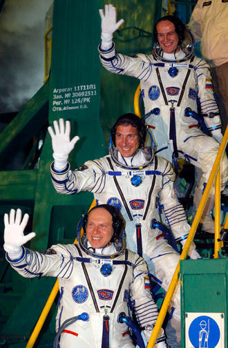 US astronaut Michael Hopkins (C) and Russian cosmonauts Oleg Kotov (L) and Sergey Ryazanskiy (R), crew members of the mission to the International Space Station (ISS), wave on September 26, 2013 before the launch of Soyuz-FG rocket at the Russian-leased Baikonur cosmodrome in Kazakhstan (AFP Photo / Pool)