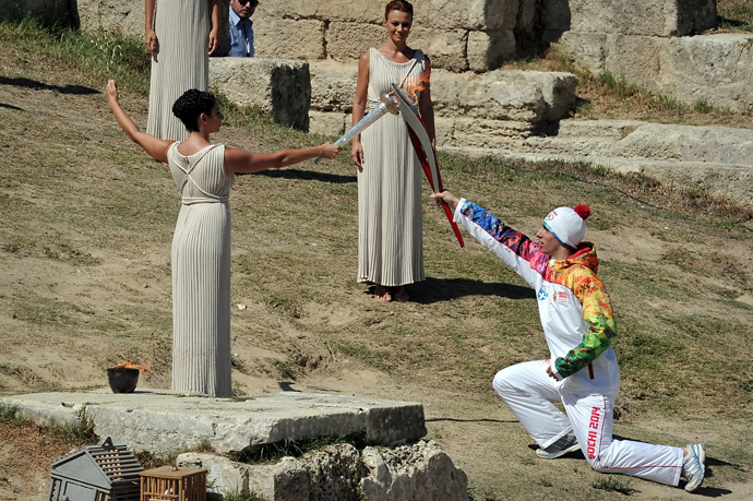 Greek actress Ino Menegakie acting as the priestesses passes the flame to the first torch bearer, Greek skier Giannis Anoniou, at the Temple of Hera on September 29, 2013 during the lighting ceremony in ancient Olympia (AFP Photo / Louisa Gouliamaki) 