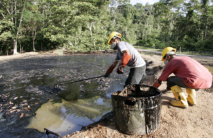 Oil workers clean up a contaminated pool in Taracoa December 10, 2007. (Reuters / Guillermo Granja)