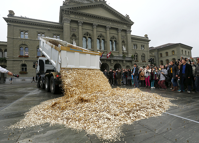 A truck dumps five cent coins in the centre of the Federal Square during a an event organised by the Committee for the initiative "CHF 2,500 monthly for everyone" (Grundeinkommen) in Bern October 4, 2013. (Reuters / Denis Balibouse)