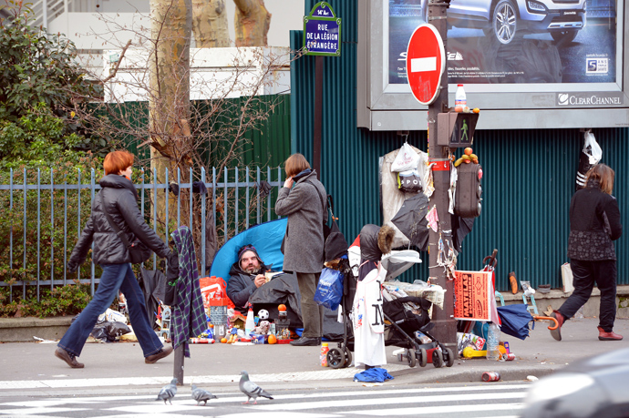 A homeless man talks to a pedestrian in the 14th district of Paris (AFP Photo / Miguel Medina)