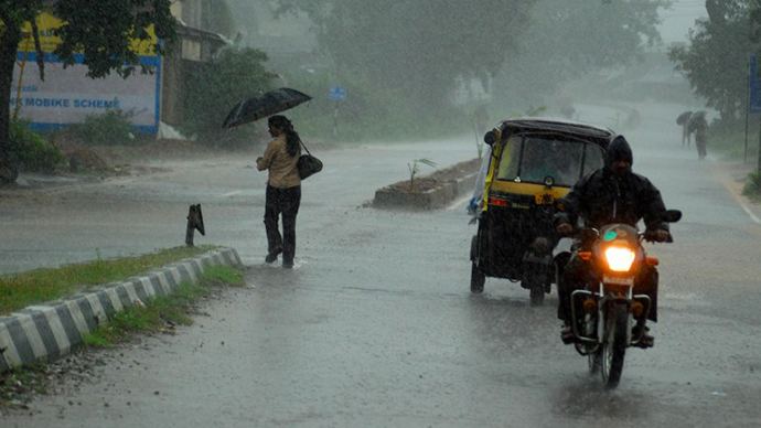 Indian residents make their way home through heavy cyclone rain in Berhampur city, about 180 kilometers south from eastern city Bhubaneswar on October 12, 2013. (AFP Photo / Asit Kumar)