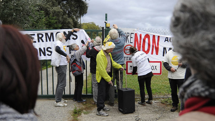 Anti-GMO (genetically modified foods) protestors install banners in front of the site entrance of US seed company Monsanto on October 12, 2013 during a day of action against the company, in Monbequi, southern France. (AFP Photo / Pascal Pavani) 