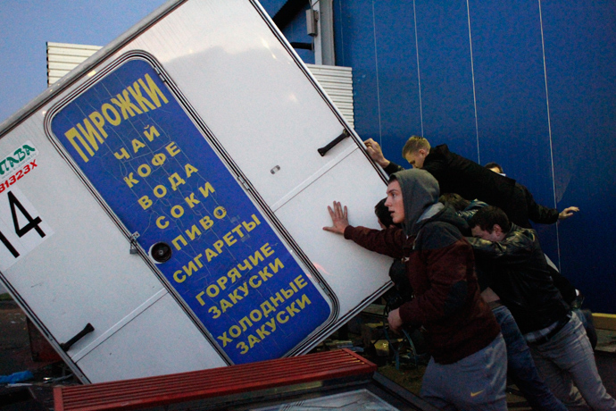 People turn over a kiosk in a vegetable warehouse in the Biryulyovo district of Moscow October 13, 2013 (Reuters / Maxim Shemetov)