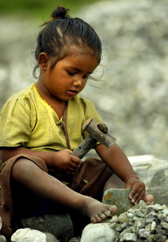 Five-year-old Rina breaks stones in Siliguri in this picture taken September 2, 2004. Rina has been a professional rock breaker for a year, slaving six days a week in the sapping heat and humidity of West Bengal. (Reuters/Kamal Kishore)