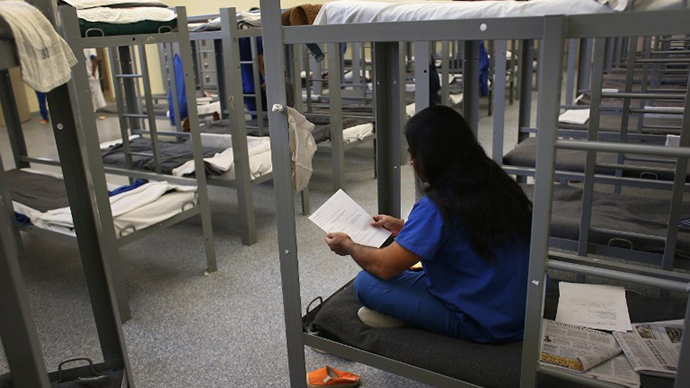 An immigration detainee from Bangladesh reads through his case papers while on his bunk at the Immigration and Customs Enforcement (ICE), detention facility (AFP Photo / John Moore)