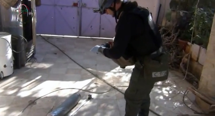 An image grab taken from a video uploaded on YouTube by Moadamiyet al-Sham media centre on August 26, 2013 allegedly shows a United Nations (UN) arms expert measuring and photographing a canister in Damascus' Moadamiyet al-Sham suburb as they investigate an alleged chemical weapons strike in the capital (AFP Photo)