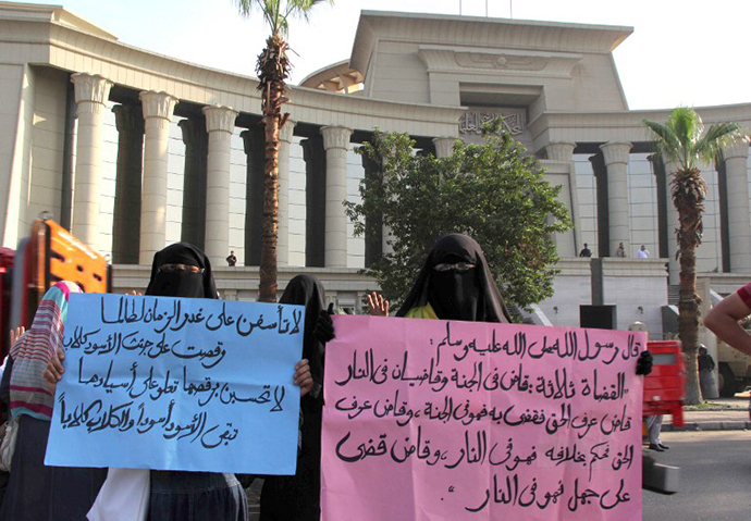 Veiled women supporters of the ousted Egyptian president Mohammed Morsi hold up signs with Islamic text written in Arabic, as they rally outside the High Court in Cairo, on November 4, 2013. (AFP Photo / Mohamed Kamel)