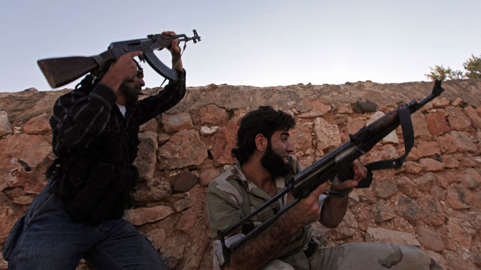 Free Syrian Army fighters fire their weapons as they take cover during clashes with what activists say are government forces, in the village of Aziza, in the southern countryside of Aleppo September 25, 2013.(Reuters / Hamid Khatib)