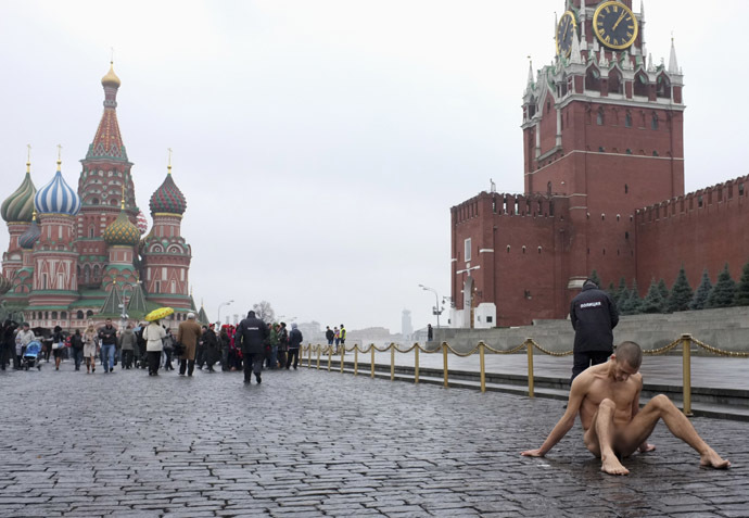 Artist Pyotr Pavlensky sits on the pavestones of Red Square during a protest action in front of the Kremlin wall in central Moscow, November 10, 2013. (Reuters/Maxim Zmeyev)