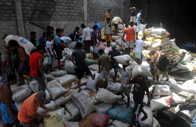Residents loot water damaged sacks of rice from a rice warehouse in the aftermath of Super Typhoon Haiyan in Tacloban in the eastern Philippine island of Leyte on November 11, 2013. (AFP Photo / Noel Celis)