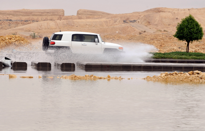 A car drives through a flooded street in northern Riyadh, on November 17, 2013, after heavy rains fell overnight in the Saudi capital, caused floods and traffic jams which forced the Saudi Eduction Ministry to suspend studies in schools and universities for one day (AFP Photo / Fayez Nureldine)
