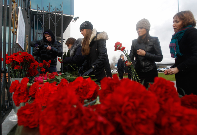 People lay flowers near a fence of Kazan airport, where a Tatarstan Airlines Boeing 737 crashed, November 18, 2013 (Reuters / Maxim Shemetov)