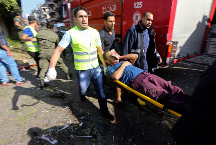 Civil defence personnel carry a wounded man at the site of explosions near the Iranian embassy in Beirut November 19, 2013.(Reuters / Hasan Shaaban)