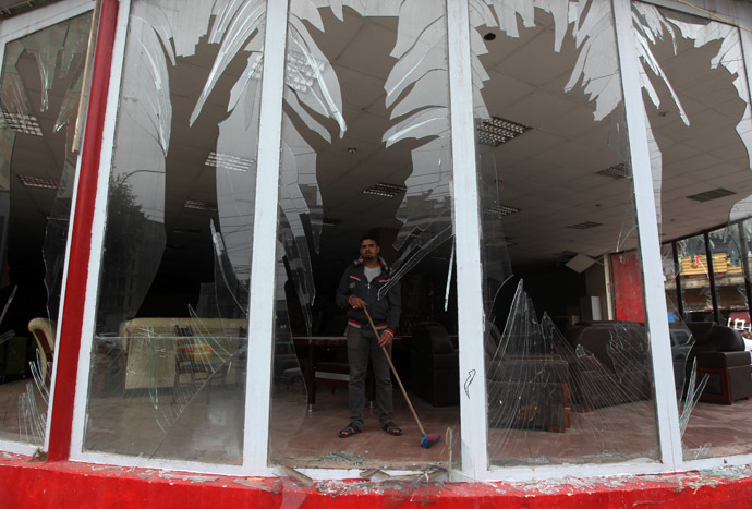 An Iraqi man clean debris from a shop after a car bomb attack in the Karrada neighborhood in central Baghdad on November 20, 2013. (AFP Photo/Ahmad Al-Rubaye)