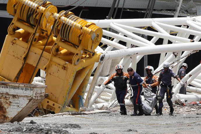 Rescuers carry the body of a worker who died after a crane fell across part of the metallic structure at the Arena de Sao Paulo --Itaquerao do Corinthians-- stadium, still under construction, on November 27, 2013 in Sao Paulo. (AFP Photo / Eduardo Viana)