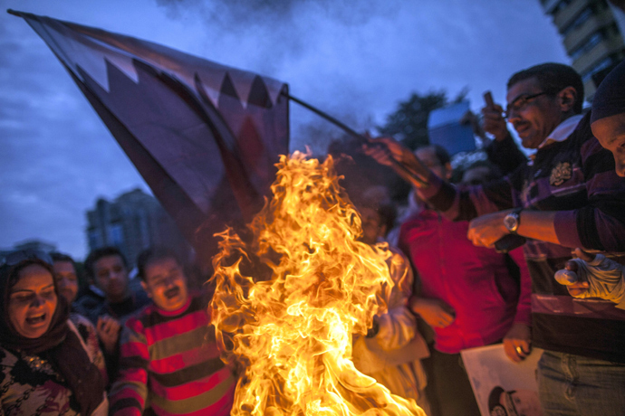 Supporters of Egypt's military chief Abdel Fattah al-Sisi burn a Qatari national flag during a demonstration outside the Qatari embassy in Cairo on November 30, 2013 (AFP Photo)
