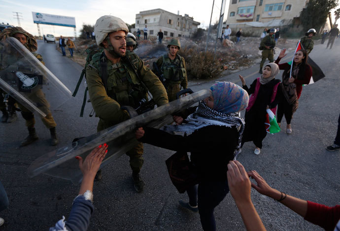 An Israeli soldier scuffles with a Palestinian protester after clashes erupted during a protest against Israel's plan of forced relocation for Bedouin residents in the southern Negev, outside the Beit El settlement near the West Bank city of Ramallah November 30, 2013.(Reuters / Mohamad Torokman )