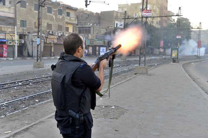 A riot policeman fires tear gas during clashes following a demonstration of Muslim Brotherhood and ousted president Mohammed Morsi supporters on December 6, 2013 in the streets of El Zeitun neighborhood close by al Qubba presidential Palace in Cairo. (AFP Photo/Mahmoud Khaled)