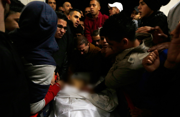 Palestinians look at the body of Wajih Majdi Al-Ramahy, 15, in Ramallah hospital December 7, 2013 (Reuters / Mohamad Torokman)