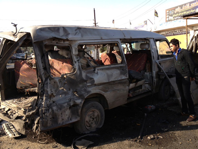 A man looks at a damaged vehicle after a car bomb attack at Bayaa district in Baghdad December 8, 2013. (Reuters / Ahmed Malik)