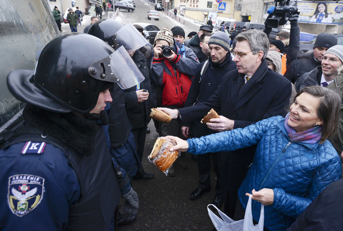 A handout picture released on December 10, 2013 by Ukrainian Union Opposition press services hows US Assistant secretary of State for European and Eurasian Affairs Victoria Nuland (R) distributing cakes to riot policemen on the Independence Square in Kiev on December 10, 2013. (AFP Photo/Andrew Kravchenko)