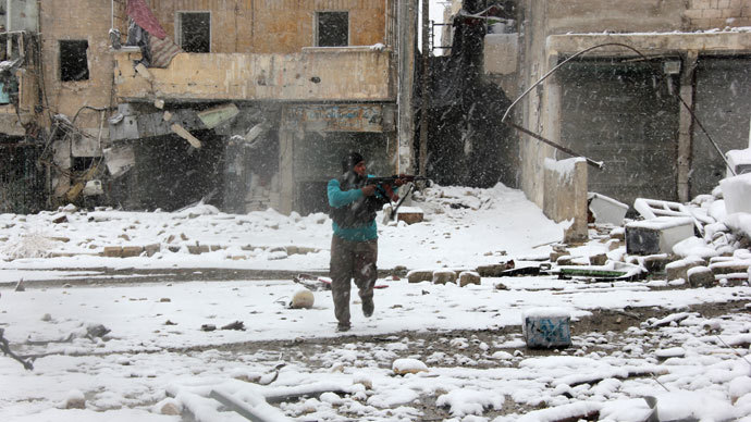A rebel fighter aims his weapon as he stands amidst snow during clashes with Syrian pro-government forces in the Salaheddin neighbourhood of Syria's northern city of Aleppo on December 11, 2013.(AFP Photo / Medo Halab)