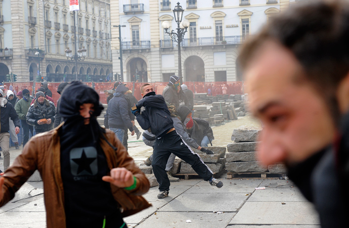 A protester throws a stone during a protest in downtown Turin December 9, 2013. (Reuters / Stringer)