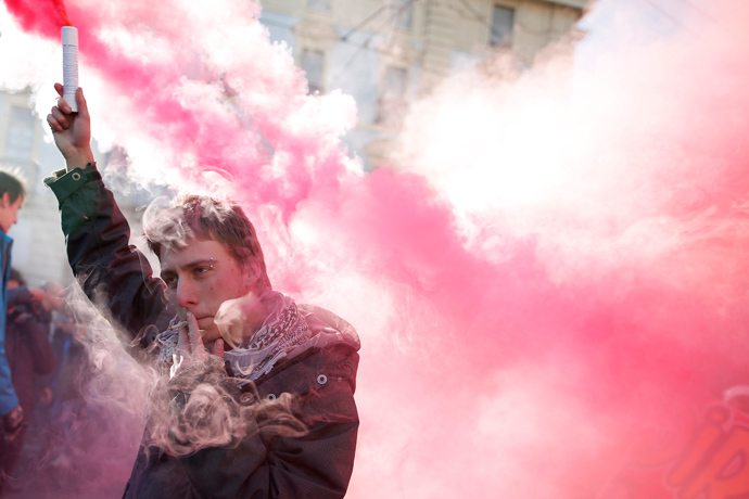 A man holds a smoke bomb during a protest by students against the local government in downtown Turin on December 14, 2013. (AFP Photo / Marco Bertorello) 
