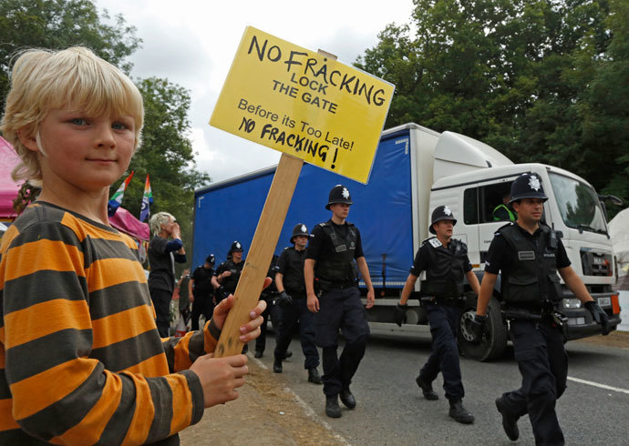 Local resident Joss Parker joins demonstrators as police escort a lorry to the entrance of a drill site run by Cuadrilla Resources, in the village of Balcombe in southern England September 3, 2013. (Reuters / Luke MacGregor)