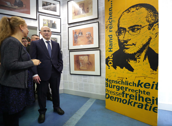 Former Russian oil tycoon and Kremlin critic Mikhail Khodorkovsky (R) and Wall Museum's director Alexandra Hildebrandt stand next to a picture of Khodorkovsky as part of the Wall Museum exhibition in Berlin on December 22, 2013. (AFP Photo/DPA)
