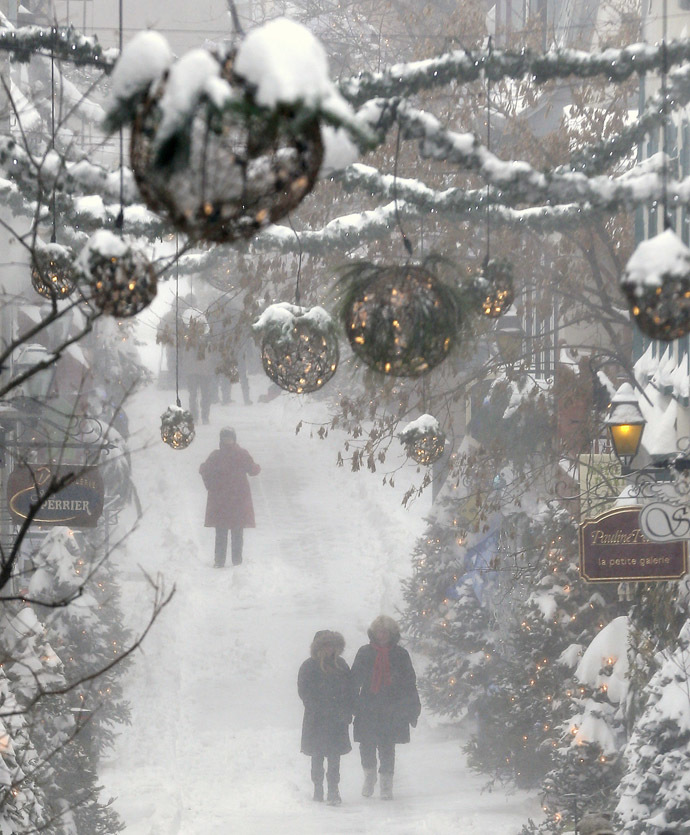 People walk in the old town during a snowstorm in Quebec City December 22, 2013. (Reuters/Mathieu Belanger)