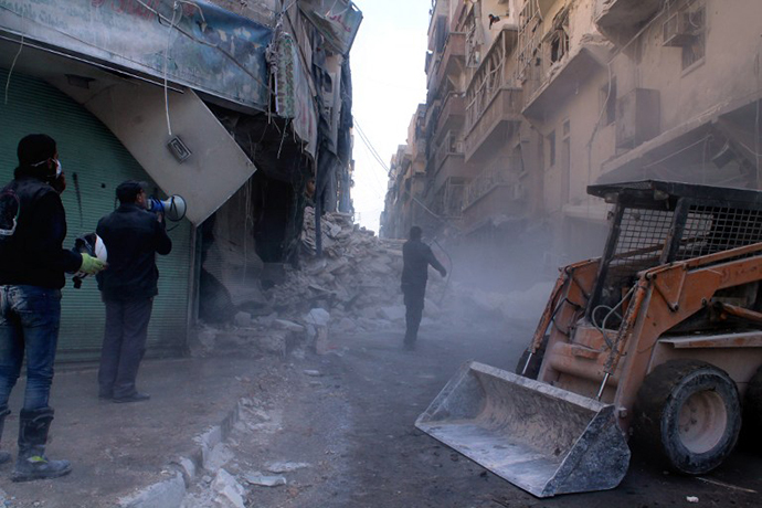 A digger arrives to remove the rubble following an airstrike in the northern Syrian city of Aleppo on December 24, 2013. (AFP Photo / Fouad Hallak)