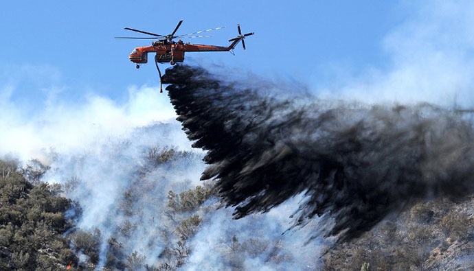A firefighting helicopter drops fire retardant on a flare up at the Powerhouse Fire, near Lake Hughes, California, approximately 66 miles (100 km) north of Los Angeles June 3, 2013. (AFP Photo / Robyn Beck)