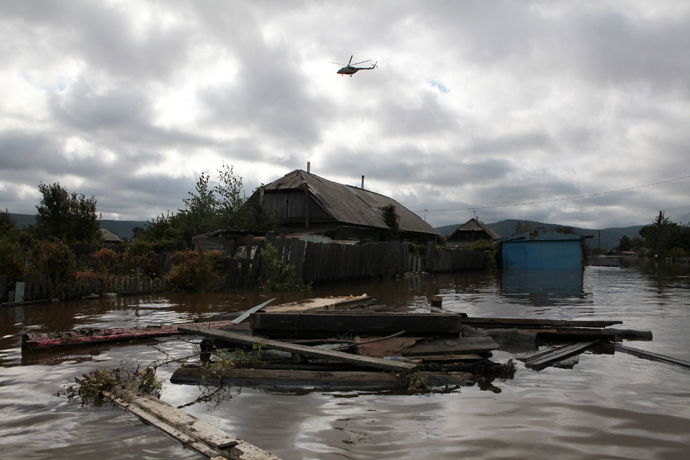 A helicopter flies over a flooded dwelling outside Komosomolsk-on-Amur in Russia's far east September 7, 2013 (Reuters / /Vladimir Barsukov)