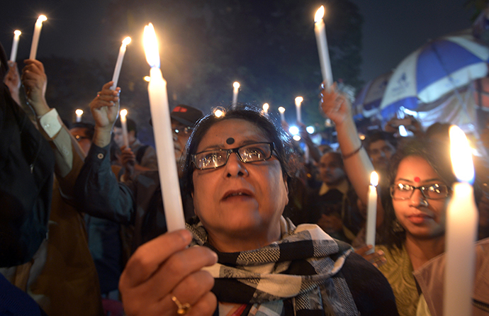 Indian activists hold candles as they participate in a mass meeting to protest against the gangrape and murder of a teenager in Kolkata on January 2, 2014. (AFP Photo / Dibyangshu Sarkar)