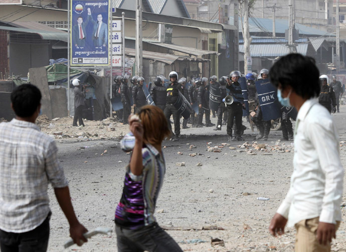 A worker throws a stone after clashes broke out during a protest in Phnom Penh January 3, 2014. (Reuters/Samrang Pring)