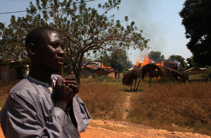 A man walks past burning houses in Bossangoa, north of Bangui January 2, 2014. (Reuters/Andreea Campeanu)