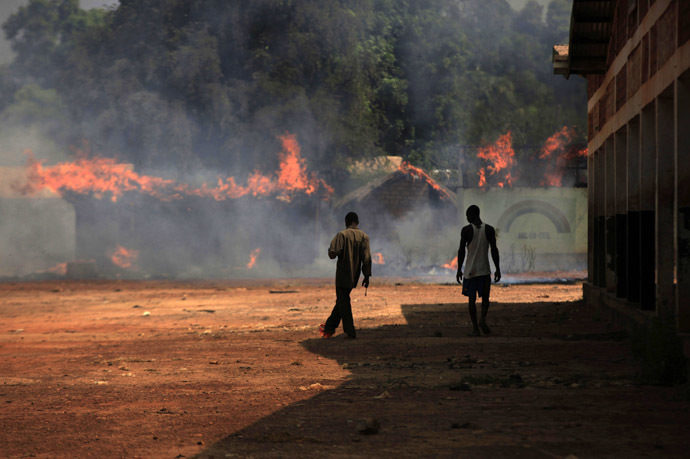 Youths walk towards burning houses in Bossangoa, north of Bangui January 2, 2014. (Reuters/Andreea Campeanu)