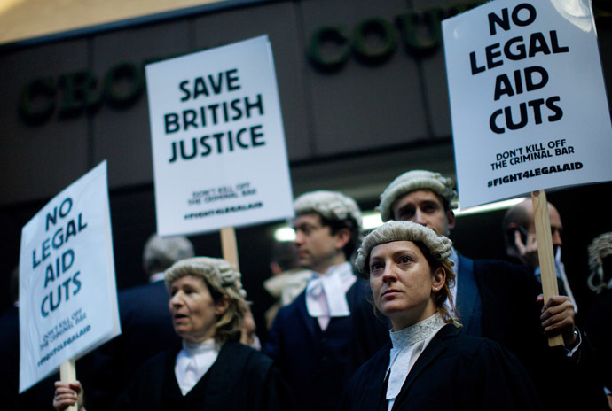 British legal professionals hold placards during a protest against cuts to the legal aid budget during a protest outside Southwark Crown Court in London on January 6, 2014 (AFP Photo/Andrew Cowie)