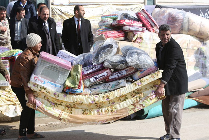 Sunni Muslim Iraqis who fled Fallujah with their families carry blankets and mattresses distributed by the International Organization for Migration (IOM) NGO on January 6, 2014 in Ayn al-Tamer in Karbala province. (AFP Photo / Ahmad Al-Rubaye)