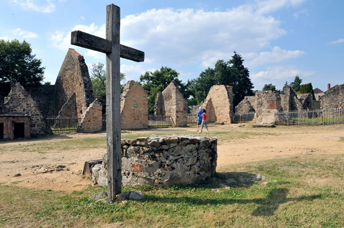 People visit on August 30, 2013 the martyr village of Oradour-sur-Glane, central France, where 642 citizens including 500 women and children were killed locked up in a church intentionally set on fire by a SS division on June 10, 1944. (AFP Photo / Thierry Zoccolan)