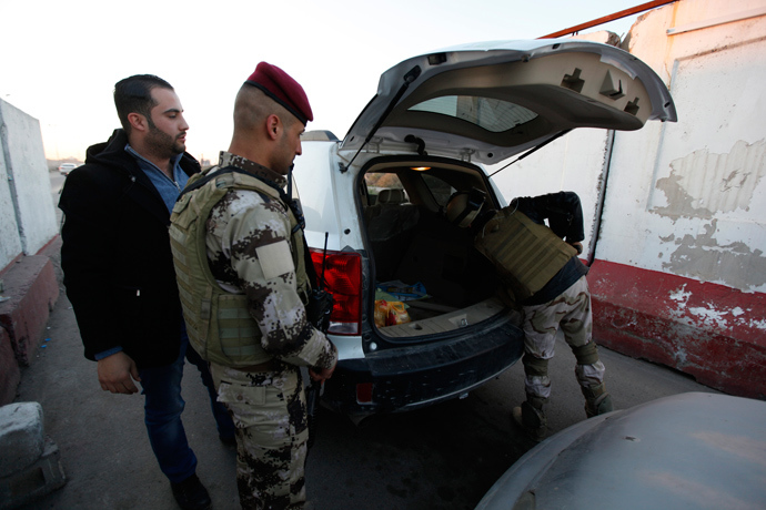 Iraqi soldiers check the trunk of a vehicle at a check point in west of Baghdad, January 8, 2014 (Reuters / Ahmed Saad)